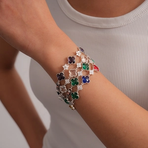 Détail d'un bracelet trèfle multicolore avec pierres zircons sur un poignet