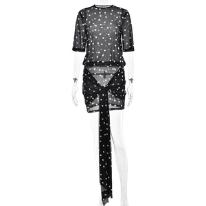 Chic black polka dot mesh two-piece set featuring short sleeve top and pleated mini skirt