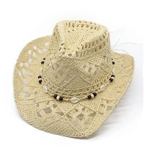 Detail of hollow-out straw cowboy hat with bohemian shell and bead decorations