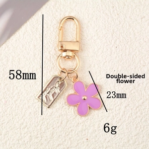 Detail of colorful double-sided enamel flower pendant on a golden keychain hook