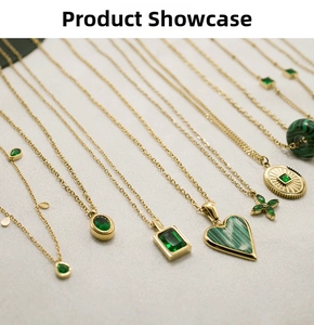 Detailed flat lay of assorted gold stainless steel necklaces with green zircon pendants
