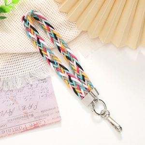 Colorful hand-woven phone wrist strap with silver metal buckle and ring on artistic background