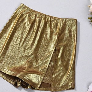 Close-up of metallic gold pleated skort showing vertical texture and shimmering finish