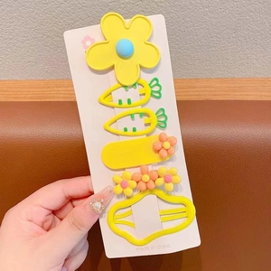 Détail d'un lot de 5 barrettes jaunes pour enfants avec formes de carottes et fleurs