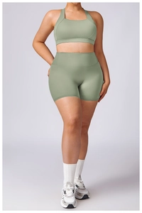 Detail of high-waist green yoga shorts and U-neck sports bra on a female model
