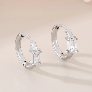 Vue détaillée de boucles d'oreilles créoles en acier argenté avec cristal carré clair
