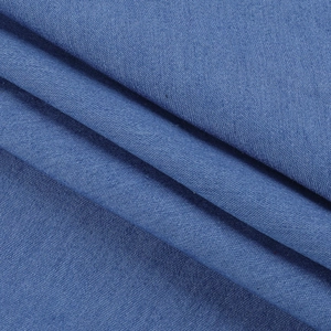 Vista macro del tessuto denim blu che mostra pieghe morbide e trama dettagliata dell'abito