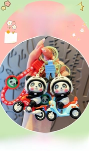 Dettaglio portachiavi panda su moto con cinturino intrecciato e chiusura in metallo dorato