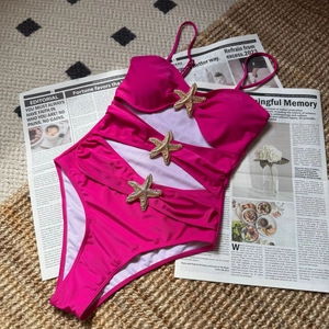 Detailed view of rose red cutout swimsuit featuring three golden starfish embellishments