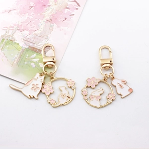 Cute cherry blossom cat and rabbit keychain, exquisite enamel metal bag pendant detail.
