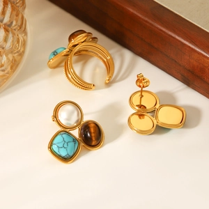 Macro view of vintage gold jewelry set with pearls, tiger eye, and turquoise stones