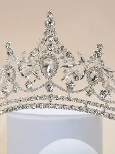Detailed close-up of a silver bridal crown with intricate leaf patterns and sparkling rhinestones