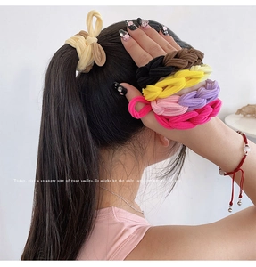 Close-up of colorful braided hair ties in beige, black, and purple for high ponytails