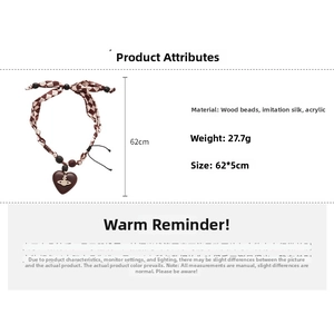 Detail showing vintage wood bead necklace with heart pendant and red checkered silk cord