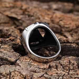 Nordic Viking triangle ring in silver stainless steel on textured bark background