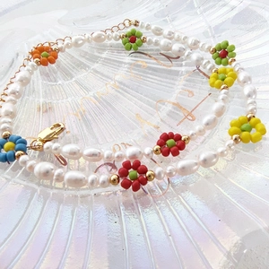Macro detail of baroque pearls and colorful beaded flowers in a shell glass tray