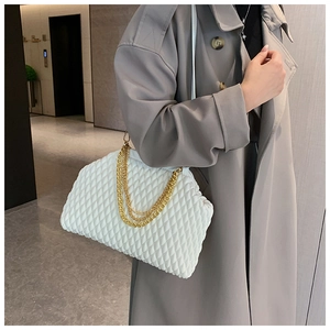 Close-up of a white pleated evening bag featuring luxurious gold multi-layer chain straps