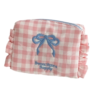 Pink checkered toiletry bag with blue bow embroidery and ruffled edges for storage