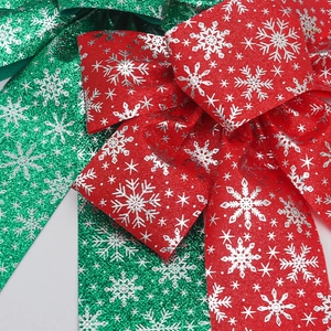 Close-up of red and green glitter Christmas bows with silver snowflake patterns for decor