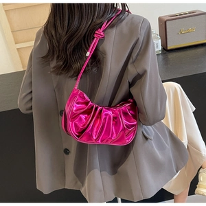 Detail of metallic purple pleated half-moon bag worn by a model in a modern office setting