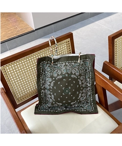 Close-up of green paisley print tote bag with decorative bohemian colorful beaded handle