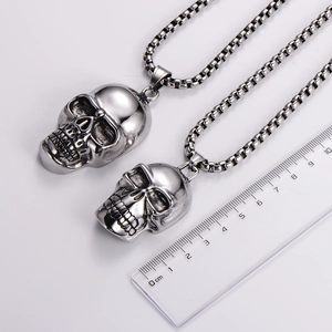 Polished stainless steel skull pendant necklaces with box chain on a white background