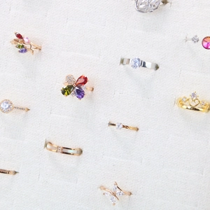 Close-up of assorted rings featuring heart, crown, and floral designs on a velvet display