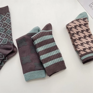 Detail view of retro plaid wool socks with diamond grid, floral and striped patterns