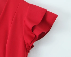 Detail of red tiered ruffle sleeves and concealed zipper on a solid woven dress