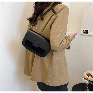 Elegant black leather shoulder bag styled with a beige blazer for a modern aesthetic look