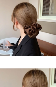 Detail of elegant dark brown satin bow scrunchie styled on a low ponytail hair
