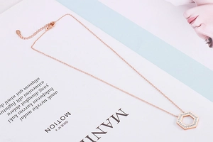Detailed close-up of rose gold hexagonal necklace with S925 hallmark and sparkling zircon stones