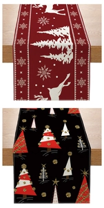 Macro detail of red reindeer and black Christmas tree patterned festive table runners