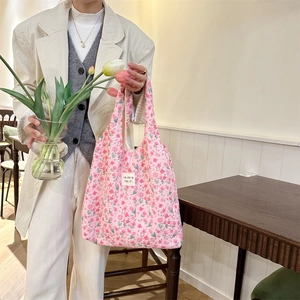 Detailed close-up of pink floral quilted tote bag featuring soraka beauté label and cotton texture