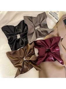 Detail of square pleated faux leather hair ties in black, grey, brown, and wine red