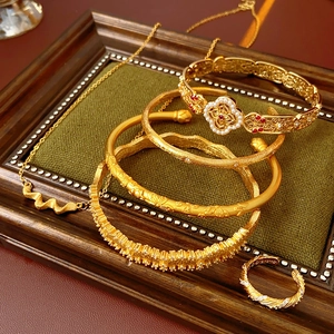 Detailed view of vintage gold bracelets and rings with red and white gemstones