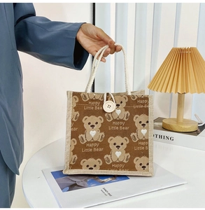 Detailed shot of brown canvas tote bag with bear print and sturdy top handle