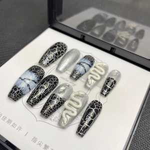 Close-up of black and silver coffin press-on nails with 3D snake design and rhinestones