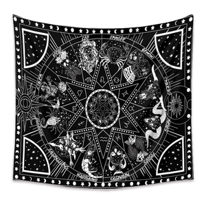 Detail of bohemian black and white tapestry featuring zodiac signs and pentagram design