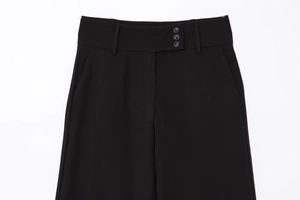 Detail der schwarzen High-Waist-Hose mit drei Zierknöpfen und seitlichen Eingrifftaschen