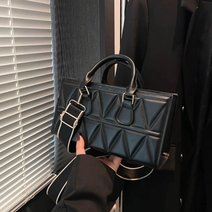 Black rectangular crossbody bag with 3D geometric triangular embossing and wide strap