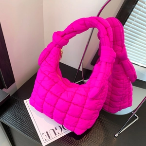 Neon pink quilted puffer handbag with knotted handle and elegant gold zipper