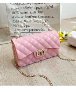 Detail of pink jelly bag with pearl handle, diamond quilt pattern and gold chain strap