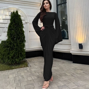 Détail des plis à la taille et manches évasées sur une robe longue noire à coupe ajustée