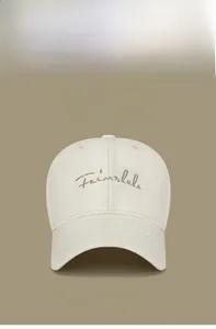 Detail of Fairmlalo cursive gold embroidery on beige cotton twill baseball cap