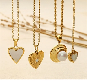 Detailed close-up of 18k gold plated necklaces with heart shell and pearl pendants