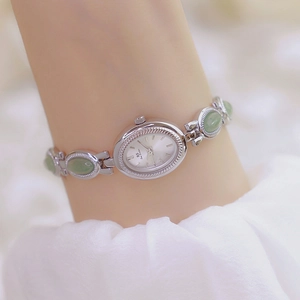 Elegant silver watch with green gemstone chain and oval white dial for women