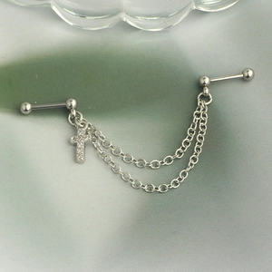 Macro view of stainless steel industrial barbell with chain and zircon cross pendant