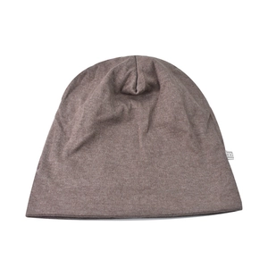 Vue détaillée du bonnet en maille marron avec strass et étiquette d'entretien du tissu