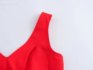 Detailed close-up of a sleeveless red dress featuring a V-neckline and smooth fabric